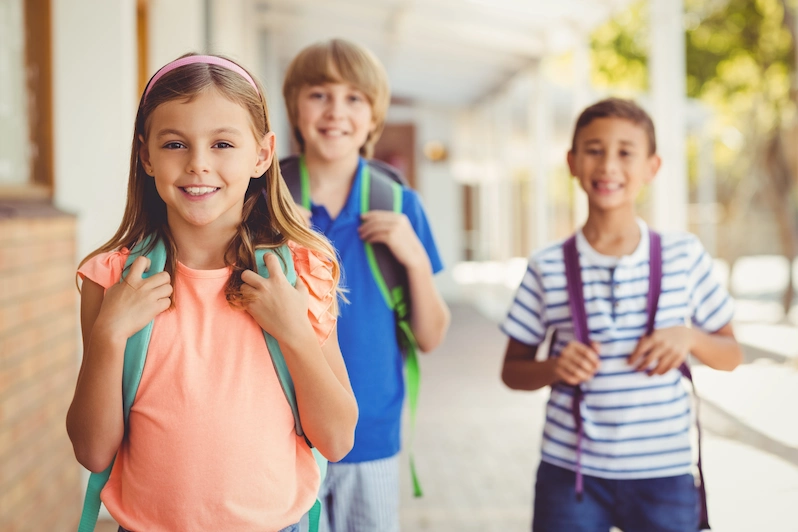 alunos em escola sorrindo para a camera