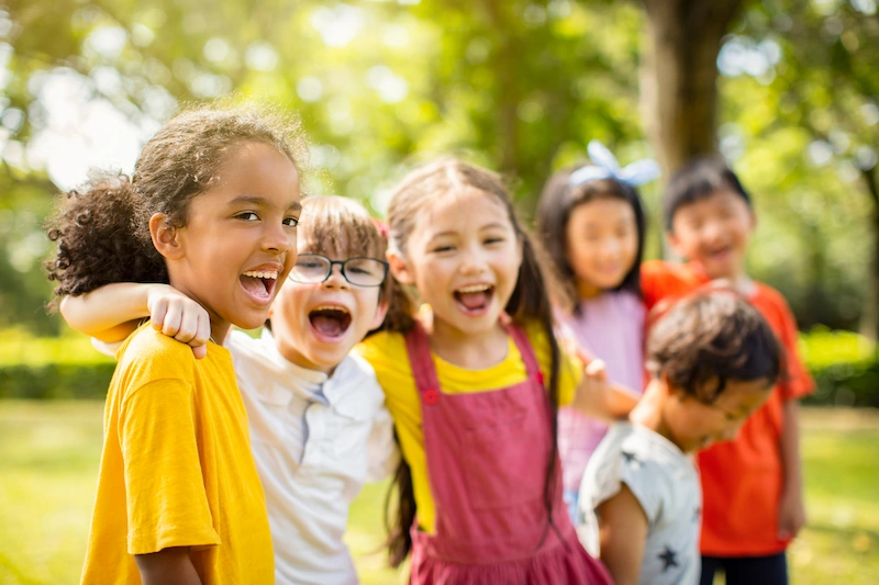 grupo diverso de criancas se abracando e sorrindo