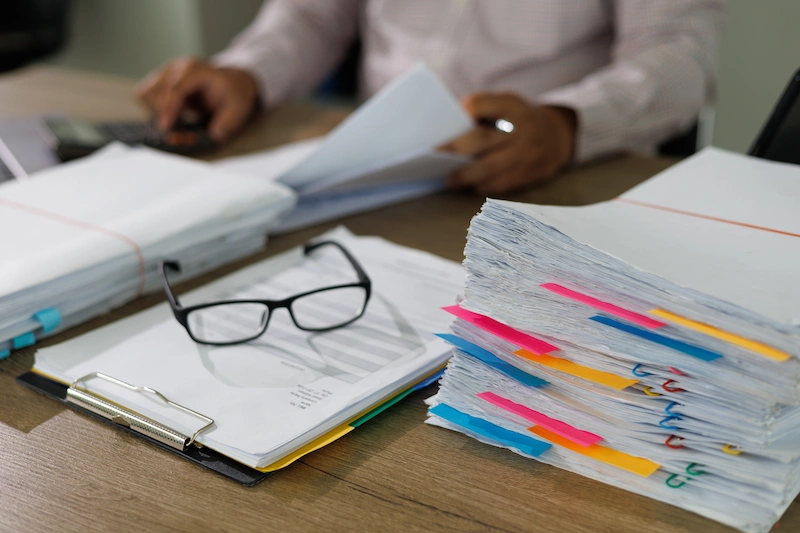 mesa de trabalho com documentos e oculos sobre